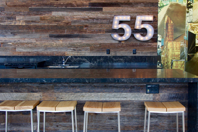 Wooden barstools against a bar