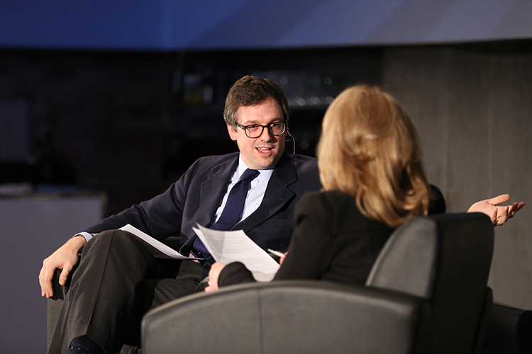 Paul Desmarais III speaking on stage, Diana Pliura facing away from camera