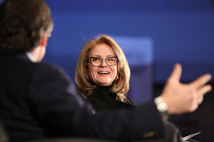 Diana Pliura laughs talking to Paul Desmarais III on stage