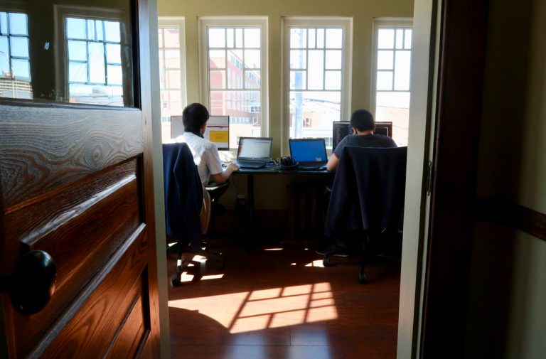 Two people working at their desks inside the InFlight office