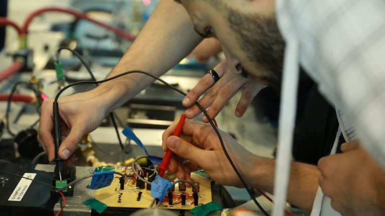 A person working on an electronic panel.